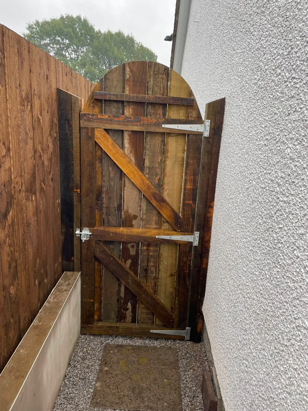 Arched timber garden gate with bracing and hinges